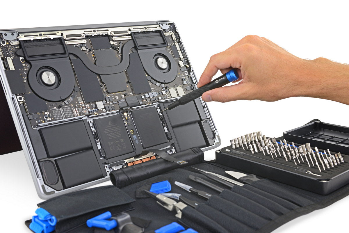 Component-level MacBook Pro logic board repair being performed under a microscope at the iAssist workshop